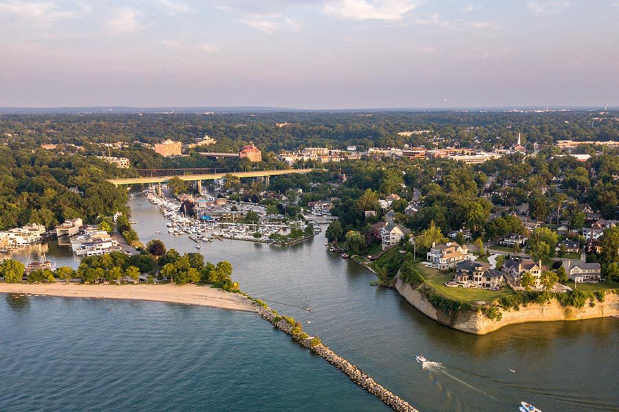 About Our Agency - Aerial View Of Rocky River, Ohio Shoreline on a Partly Cloudy Day, The Jetty and Water In the Foreground